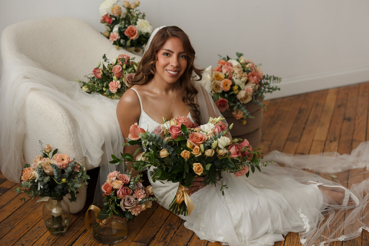 Bride surrounded by peach and coral wedding flowers