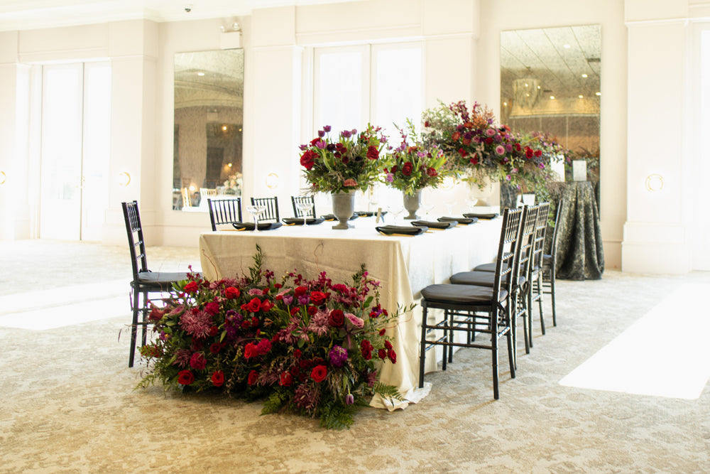 Table flowers and a floral arrangement at the end of the table by SoBro by 21 Petals at Ritz Charles in Carmel.