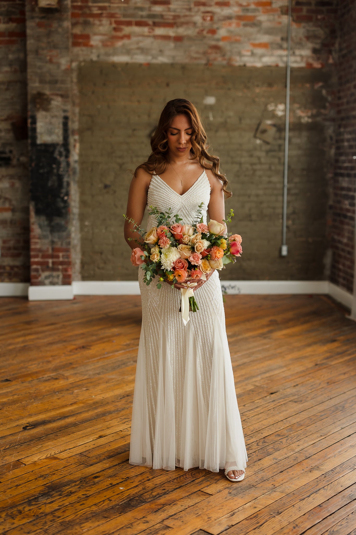 Bride holding a peach and coral wedding bouquet