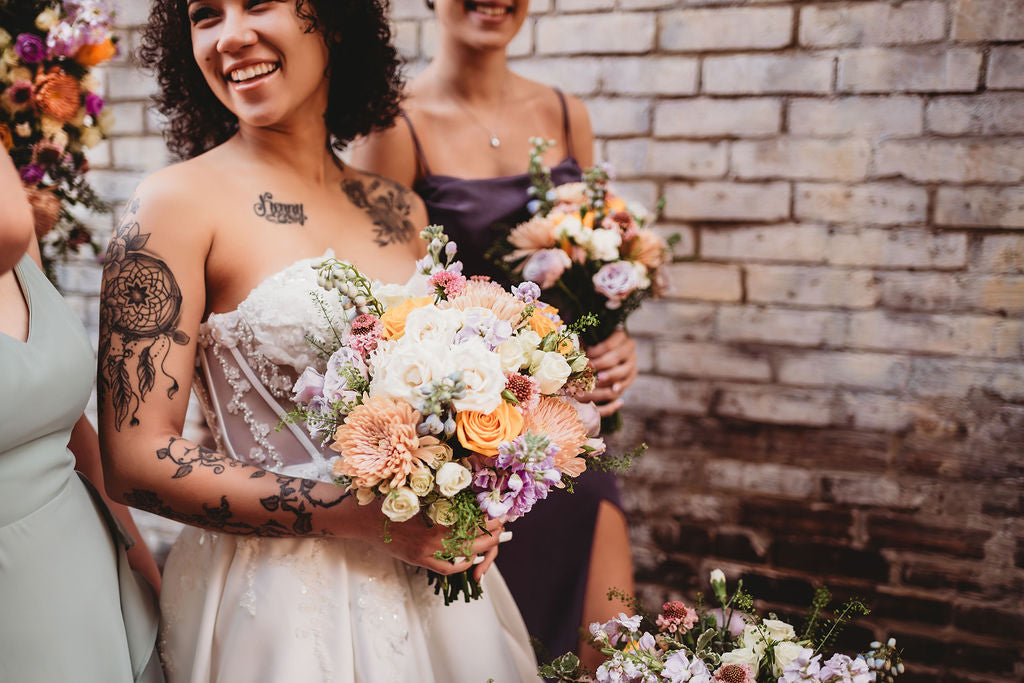 Bride and attendants holding colorful wedding bouquets