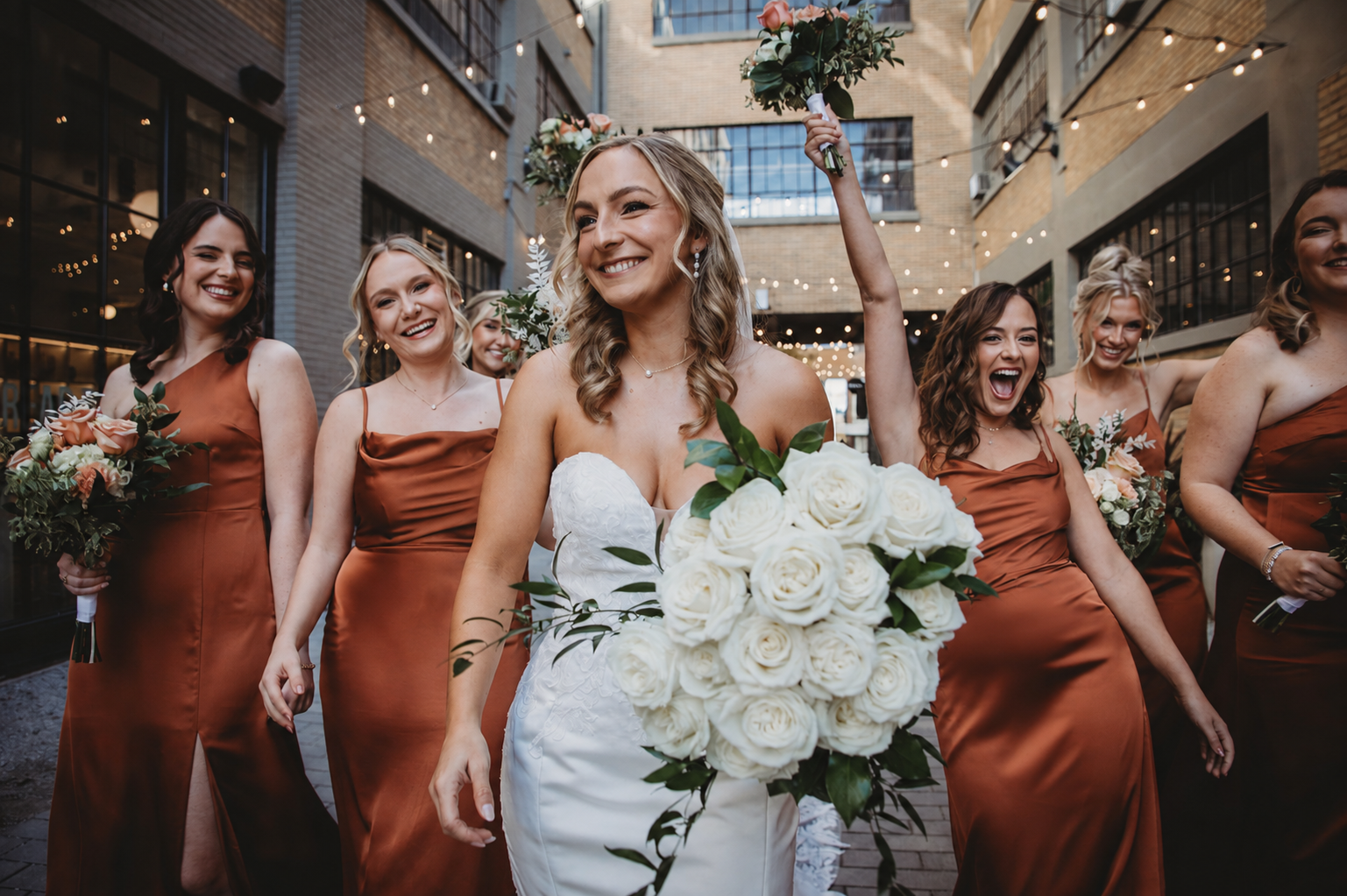 Bride and bridesmaids celebrating with wedding bouquets