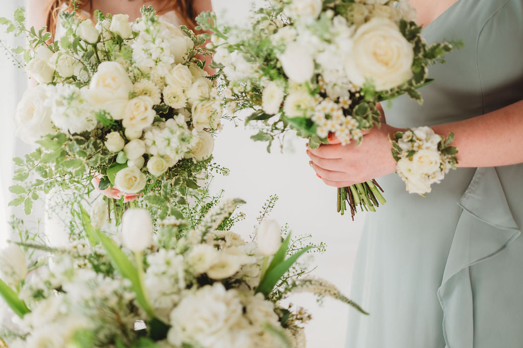 White bridal and bridesmaid bouquets with matching wrist corsage
