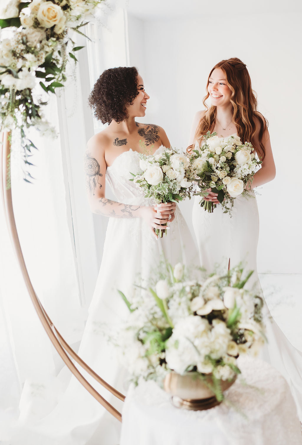 Two brides holding white wedding bouquets by 21 Petals